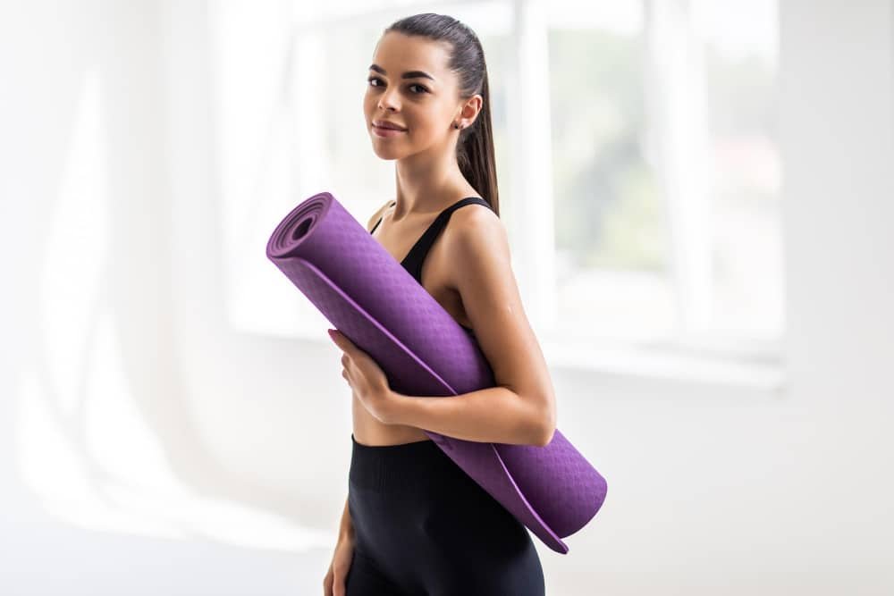 image of a woman holding a neoprene yoga mat