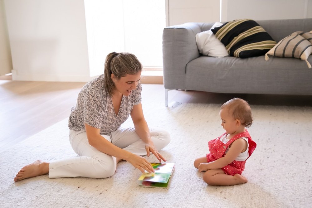 Image of a parent trying to educate a infant along with a book